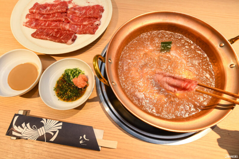 일본식 나베 요리 사진 — 스키야키와 재료가 담긴 따끈한 전골