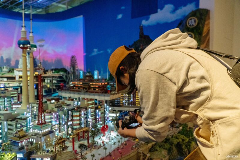ผู้เข้าชมกำลังถ่ายภาพโมเดลเมืองโตเกียวขนาดย่อมภายในพิพิธภัณฑ์